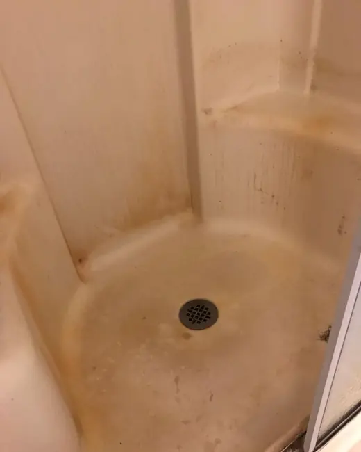 A shower stall before cleaning